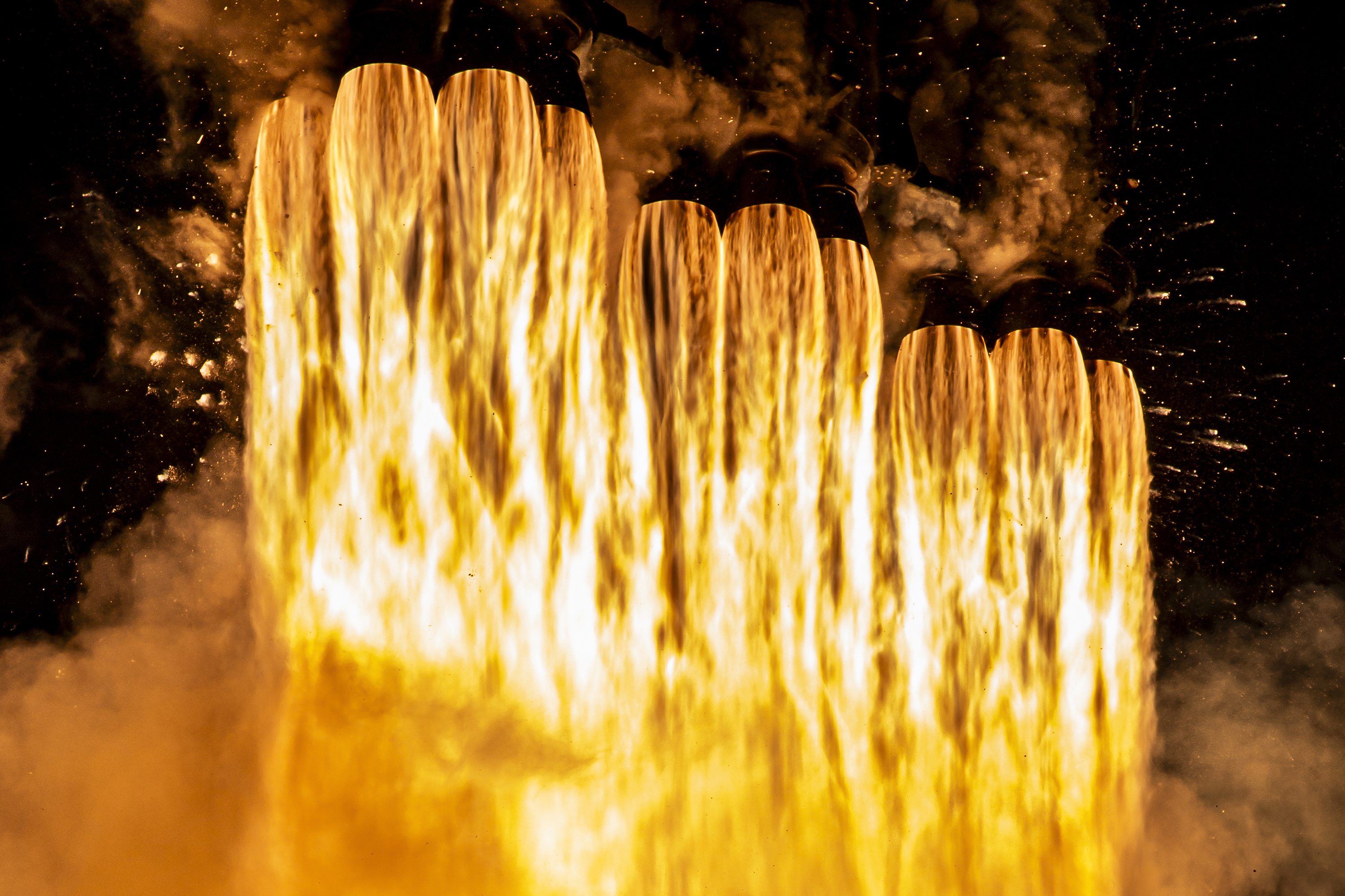 A close up of fire shooting from a collection of rocket engines.